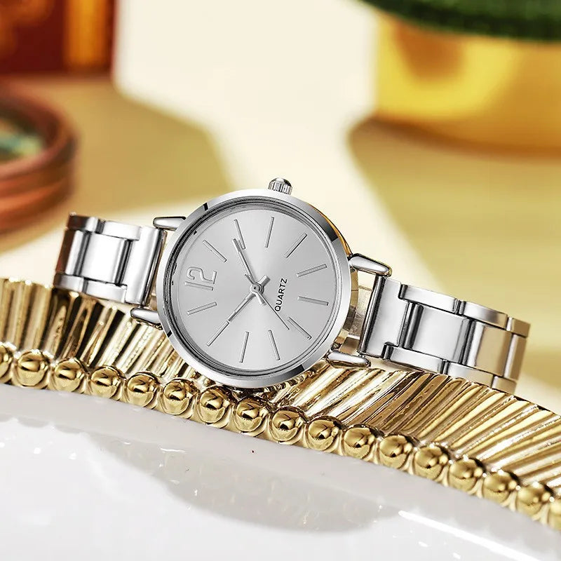 Women's quartz wristwatch with silver circular dial and metal link bracelet, Roman numerals.