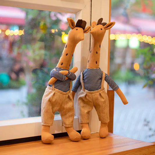Pair of giraffe plush dolls with striped shirts and tan pants, standing side by side