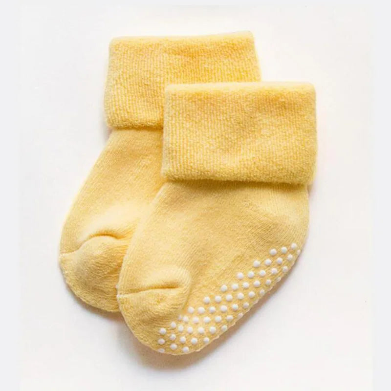 Mustard yellow thick baby socks with white grippy dots on the sole