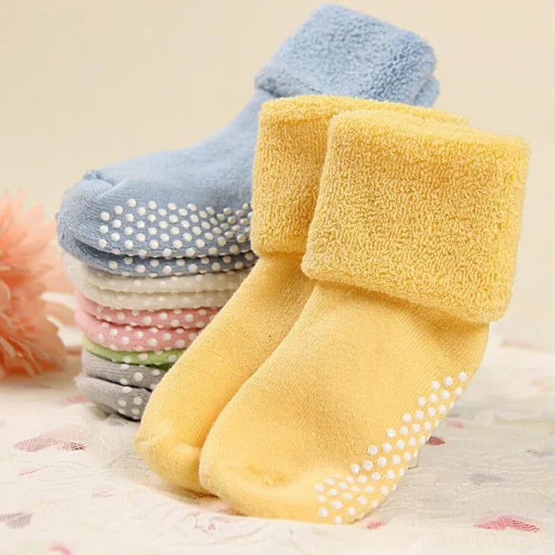 Thick baby socks in yellow and blue with grippy dots on the soles