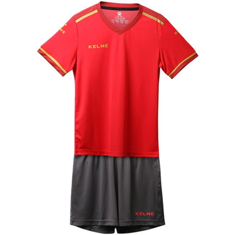 Kids red soccer jersey with V-neck and yellow trim, matching dark gray shorts, KELME logo