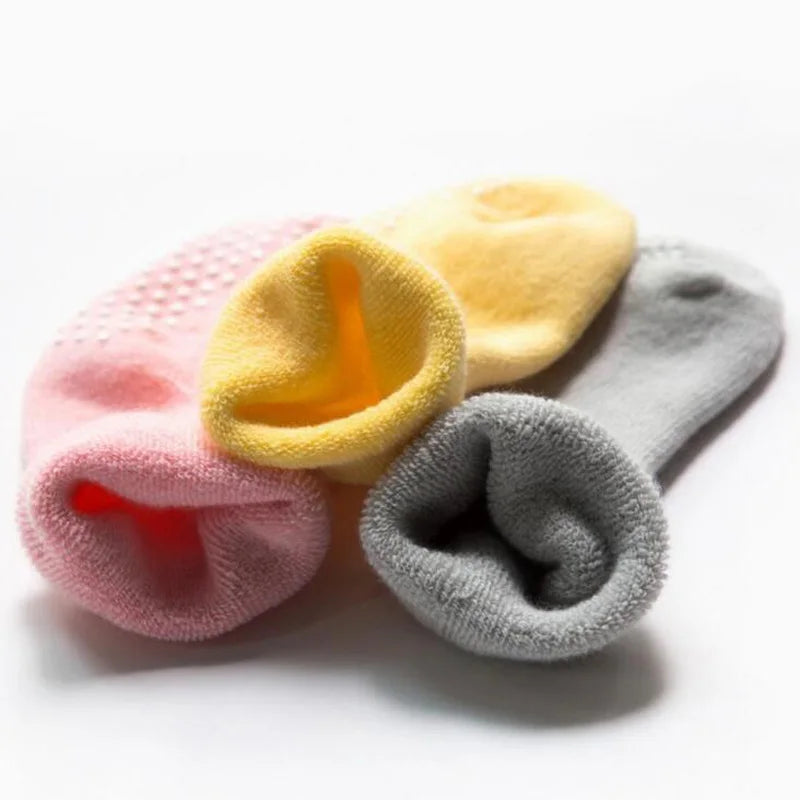 Thick baby socks in yellow, pink, gray, and light gray with grippy dot soles