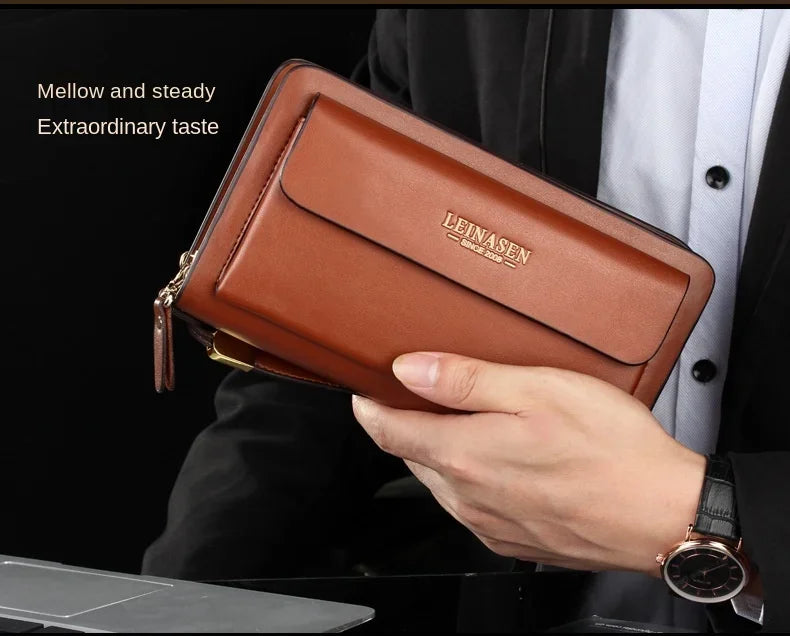 Brown wallet clutch with front flap pocket and double zipper, held in hand