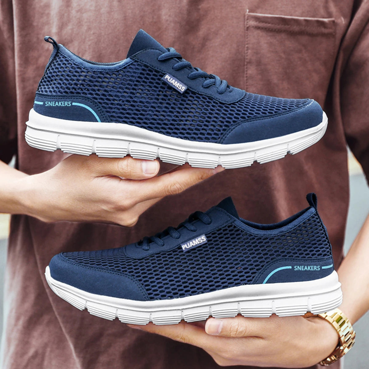 Blue mesh lace-up sneakers with white ribbed sole held in hands