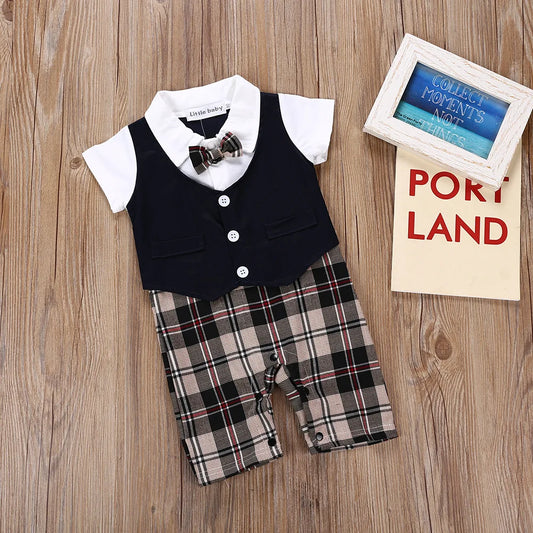 Infant boys’ gentleman suit romper with dark navy vest, bow tie, and plaid shorts