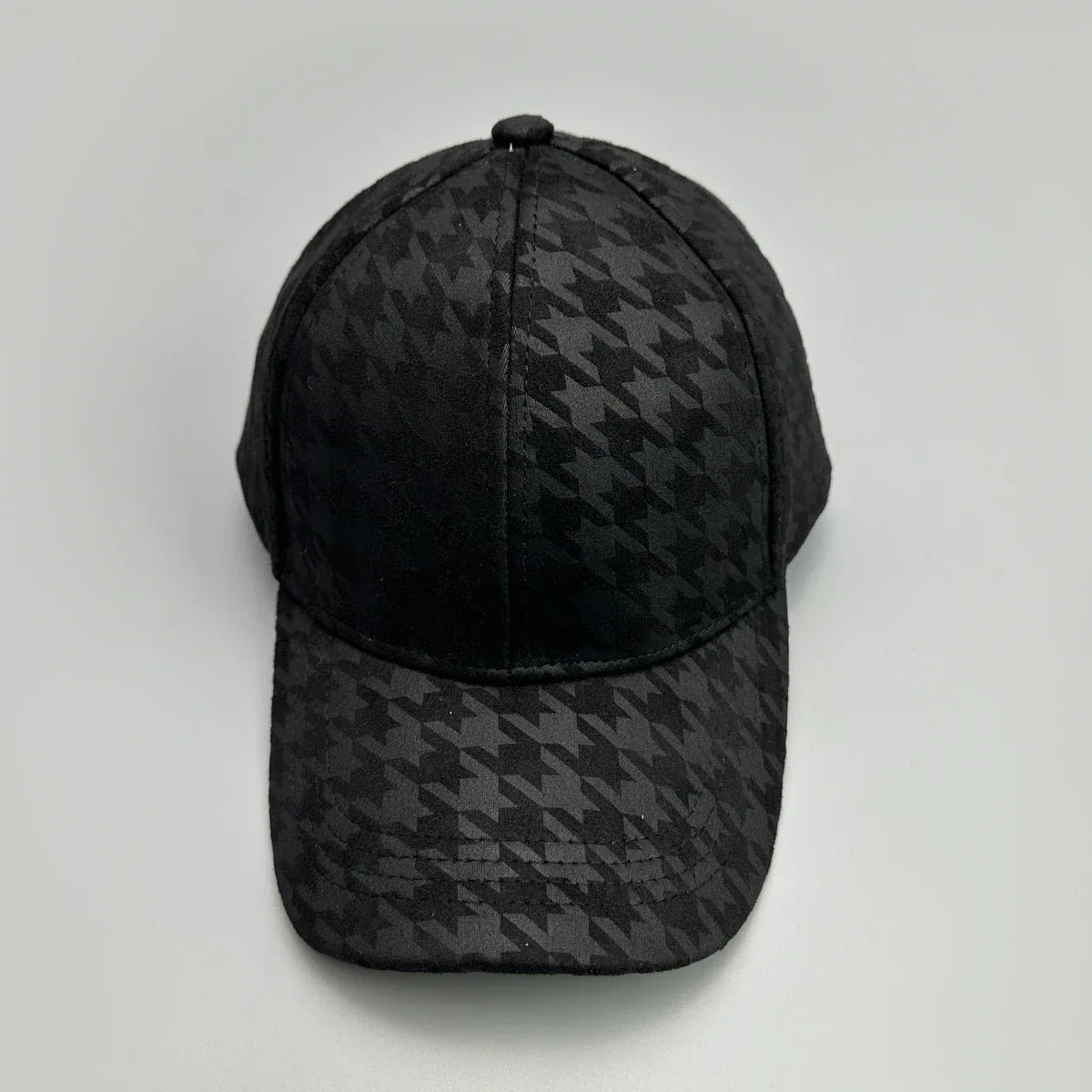 Black baseball cap with a subtle tonal houndstooth pattern on a white background.