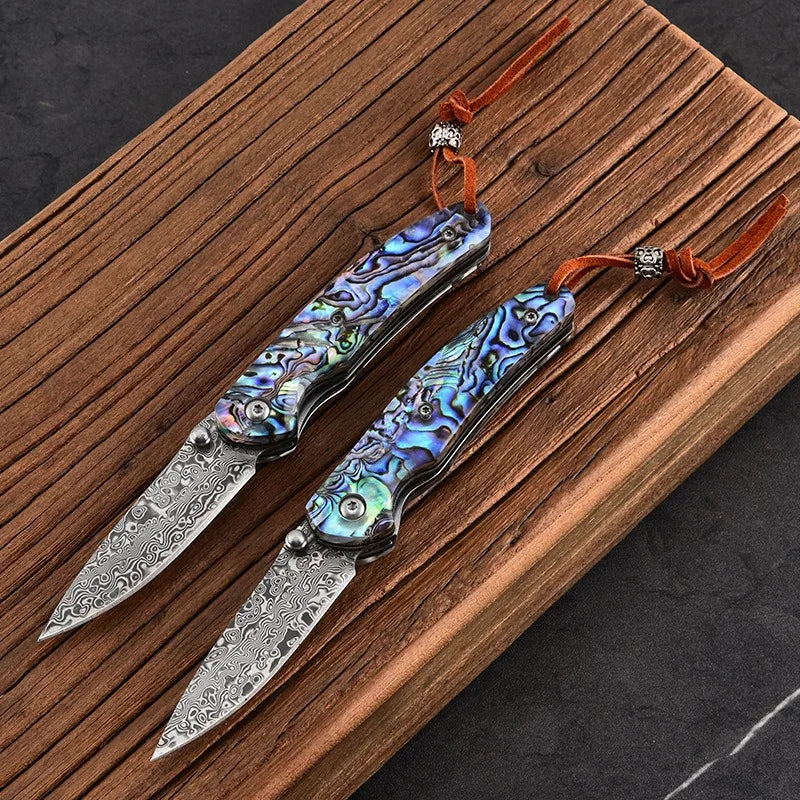 Damascus steel folding knife pair with iridescent blue handles and silver damascus blades