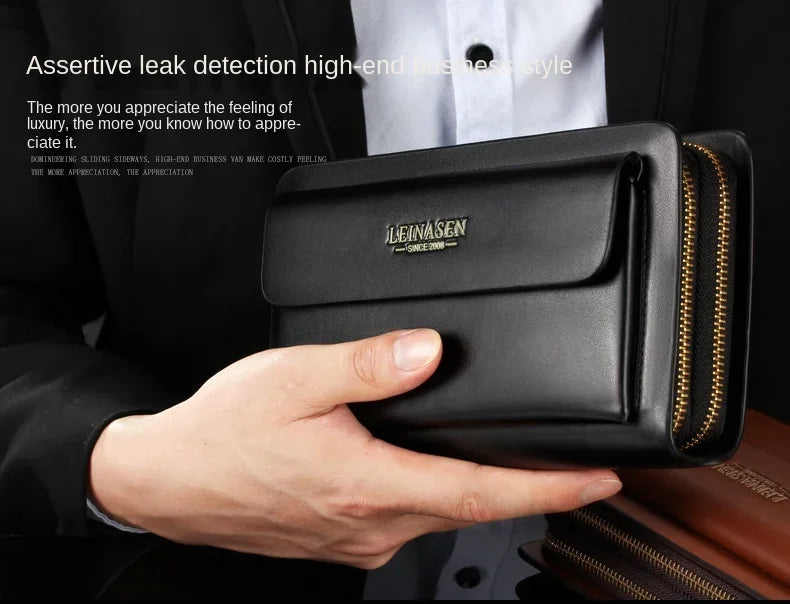 Black leather-look wallet clutch with front flap and double zipper, held in hand