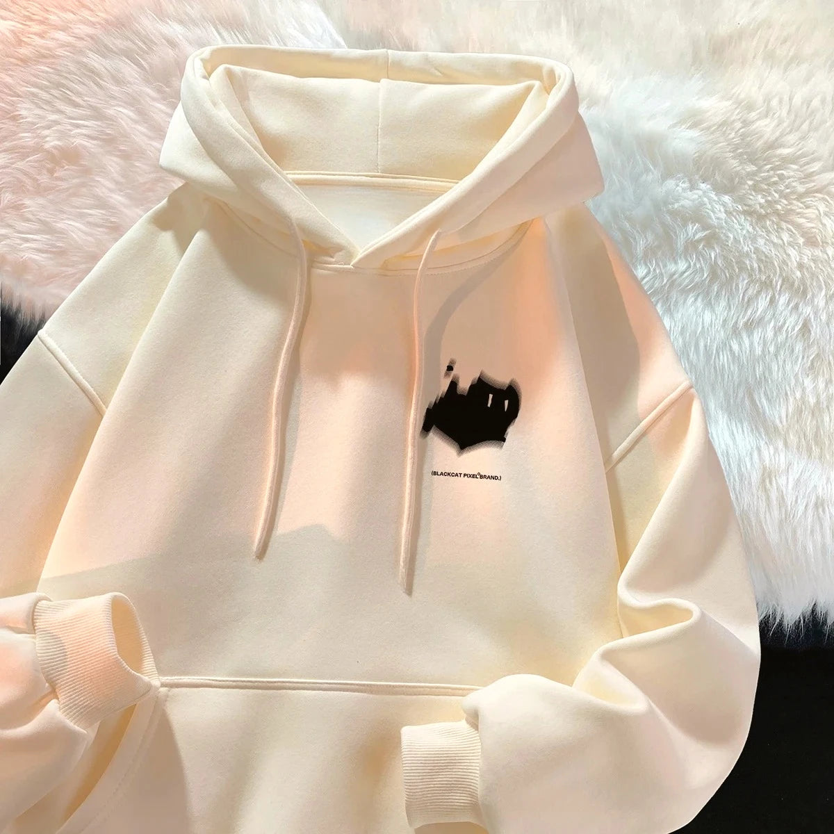Off-white oversized women's hoodie with hood, drawstrings, front pocket, and chest graphic