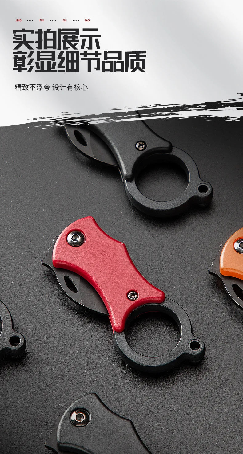 Red mini folding pocket knife with keychain ring, close-up on black handle model