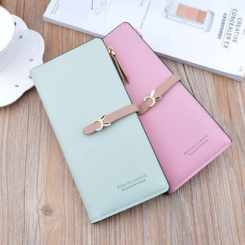 Long two-tone wallet purse in light blue and pink, with bow strap and gold zipper.