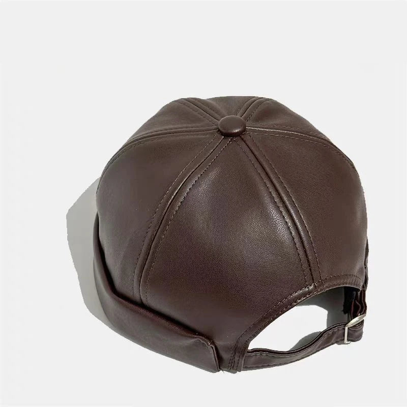 Brown PU leather docker cap, curved crown with stitched seams and top button.