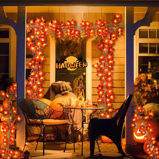 Orange maple leaf LED string lights with glowing warm bulbs on wire garland