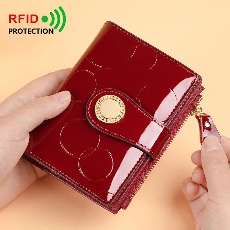 Wine red card holder wallet with gold round logo and gold-tone zipper pull, glossy