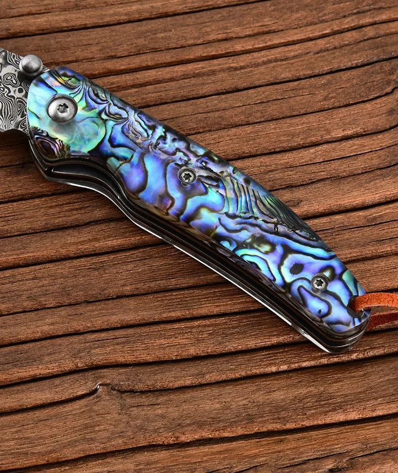 Damascus steel folding knife with iridescent blue handle and silver folding blade