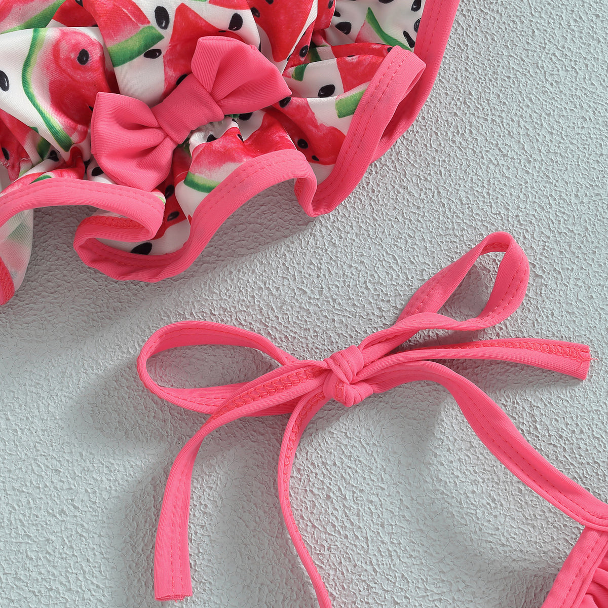 Pink halter tie and ruffle trim on toddler bikini with watermelon-print bottoms