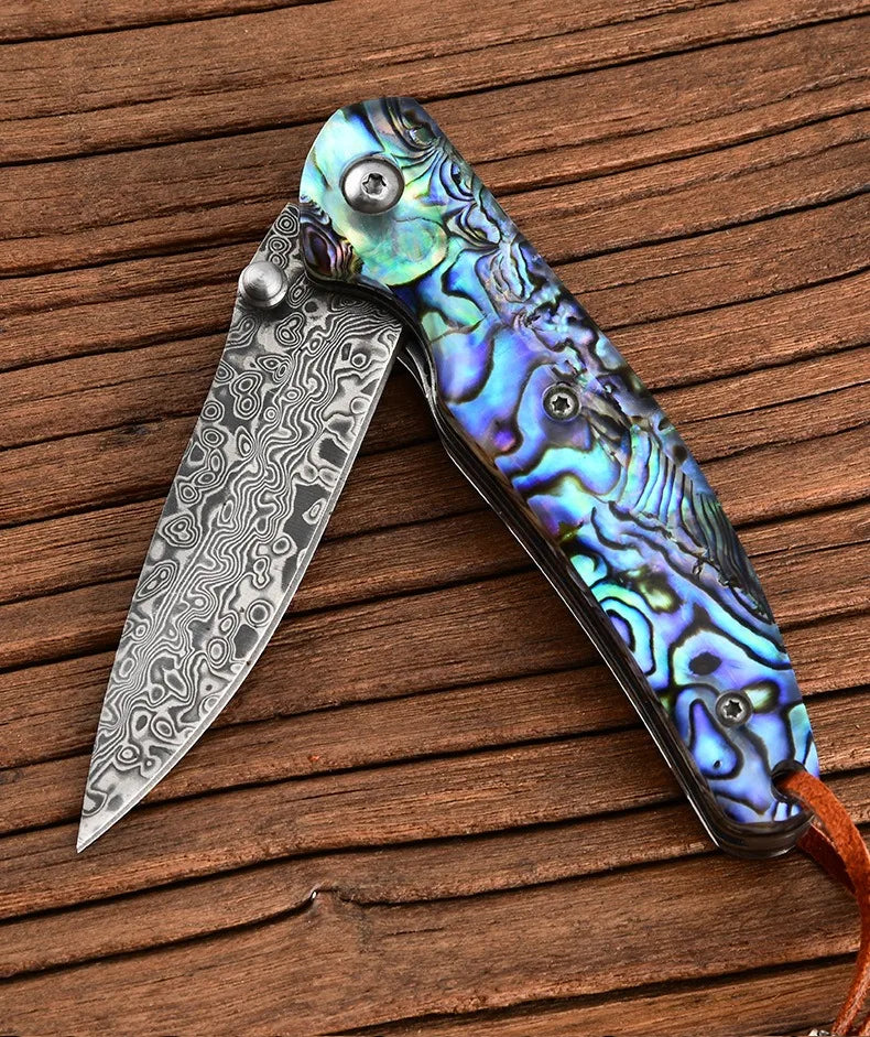 Damascus steel folding knife with iridescent blue-green handle, blade open