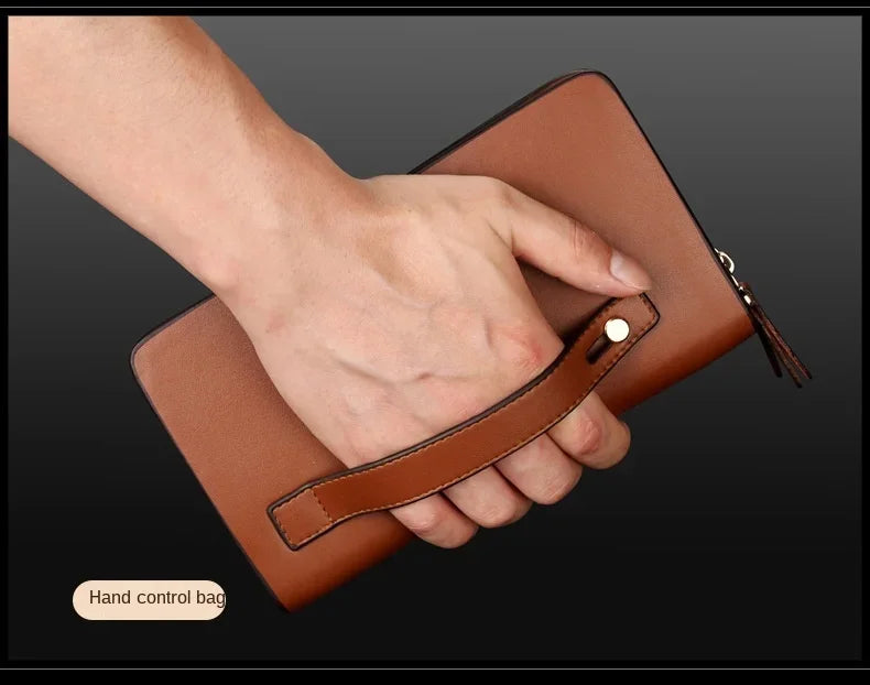 Brown wallet clutch with double zipper and wrist strap, hand holding close-up