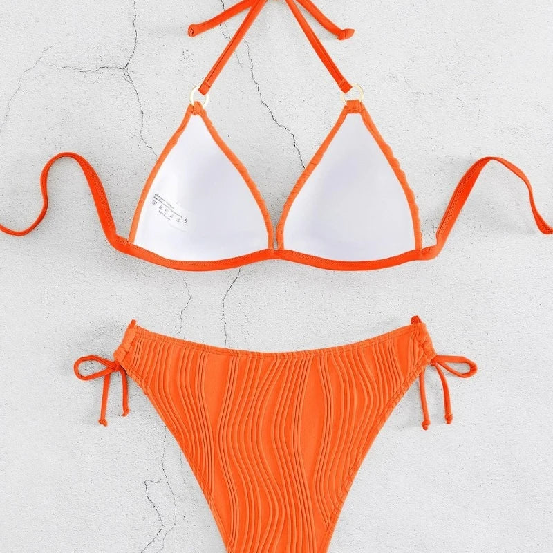 Orange ribbed triangle bikini top and matching tie-side briefs set laid flat