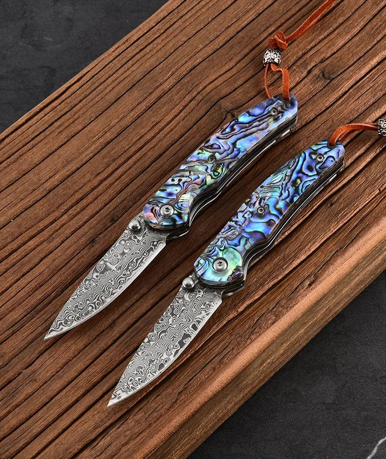 Damascus steel folding knife with iridescent blue handle and silver patterned damascus blade
