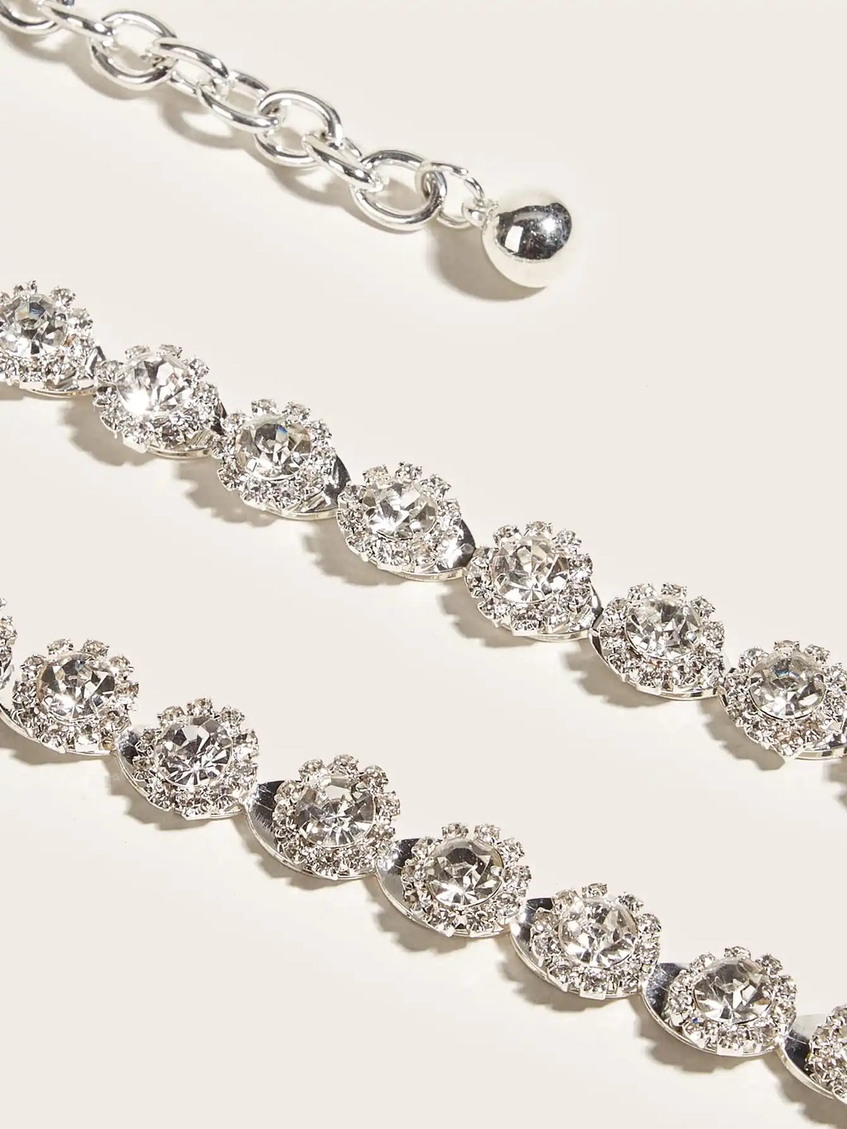 Silver rhinestone chain belt close-up with round faceted stones and metal links