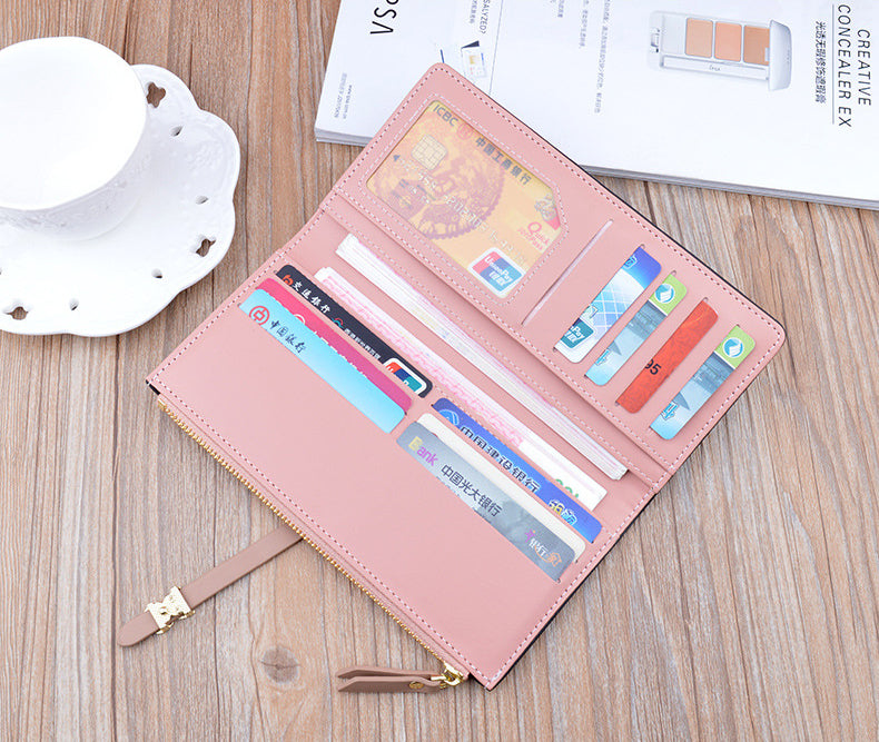 Long pink wallet purse opened, showing multiple card slots and compartments.