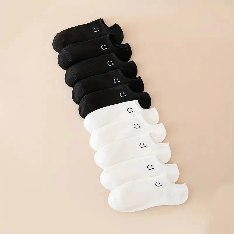 Women’s no-show socks multipack in black and white with smiley face pattern.