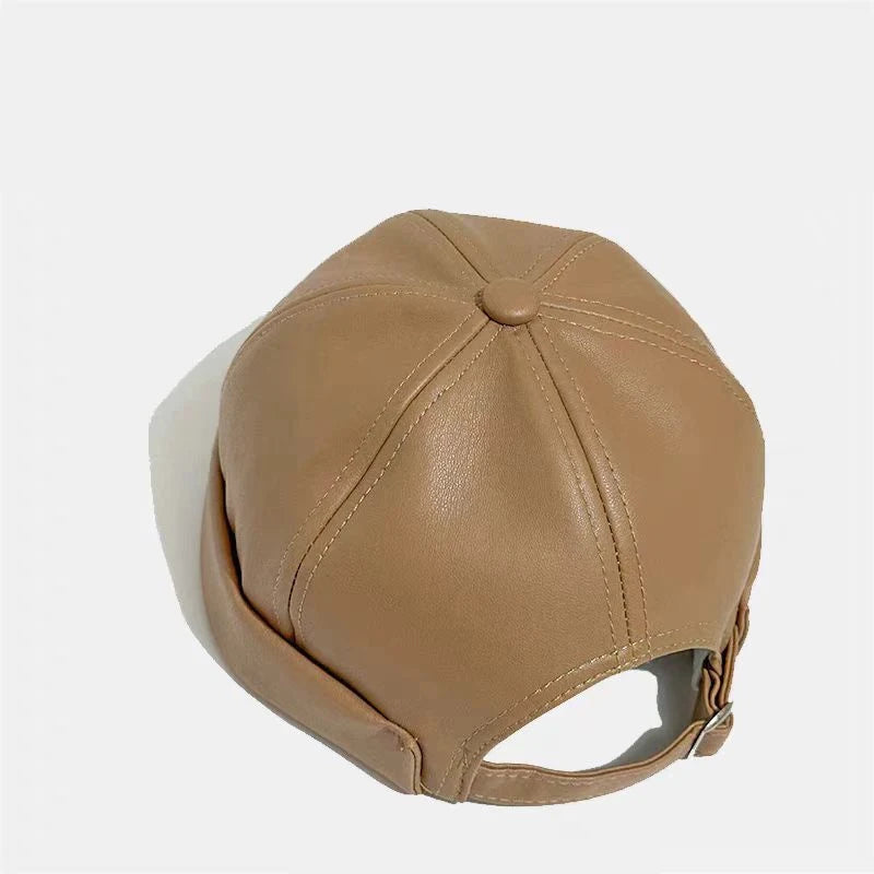 Tan PU leather docker cap, round crown with stitched panels and small top button.