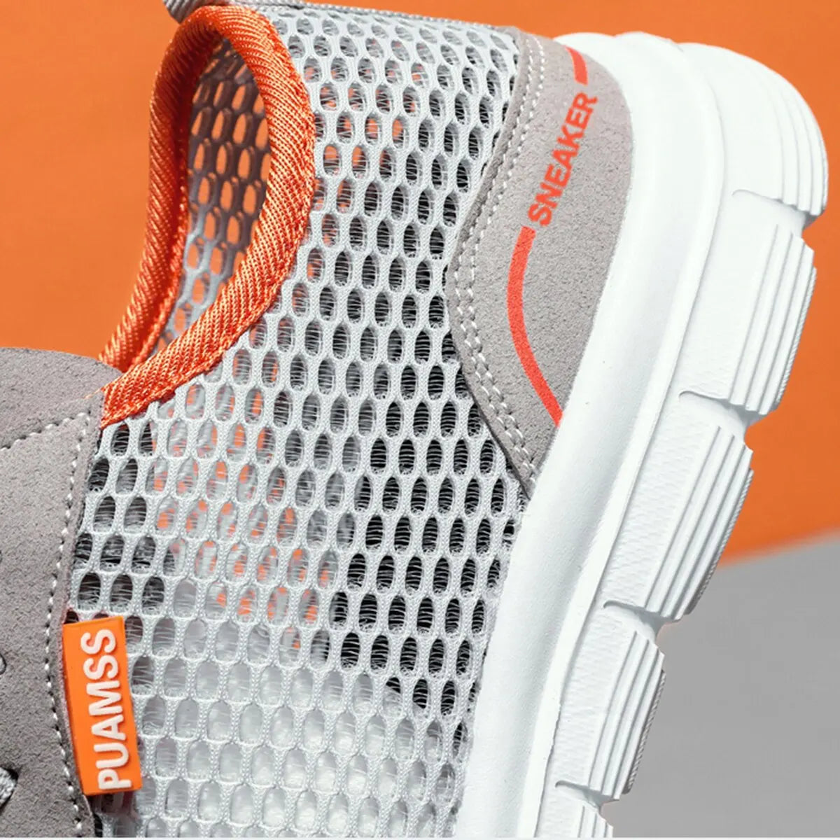 Men's sneakers close-up, gray mesh fabric with orange collar and white ribbed sole