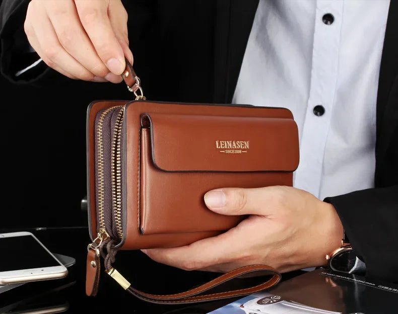 Brown wallet clutch with double zippers and money clip, held open in a hand