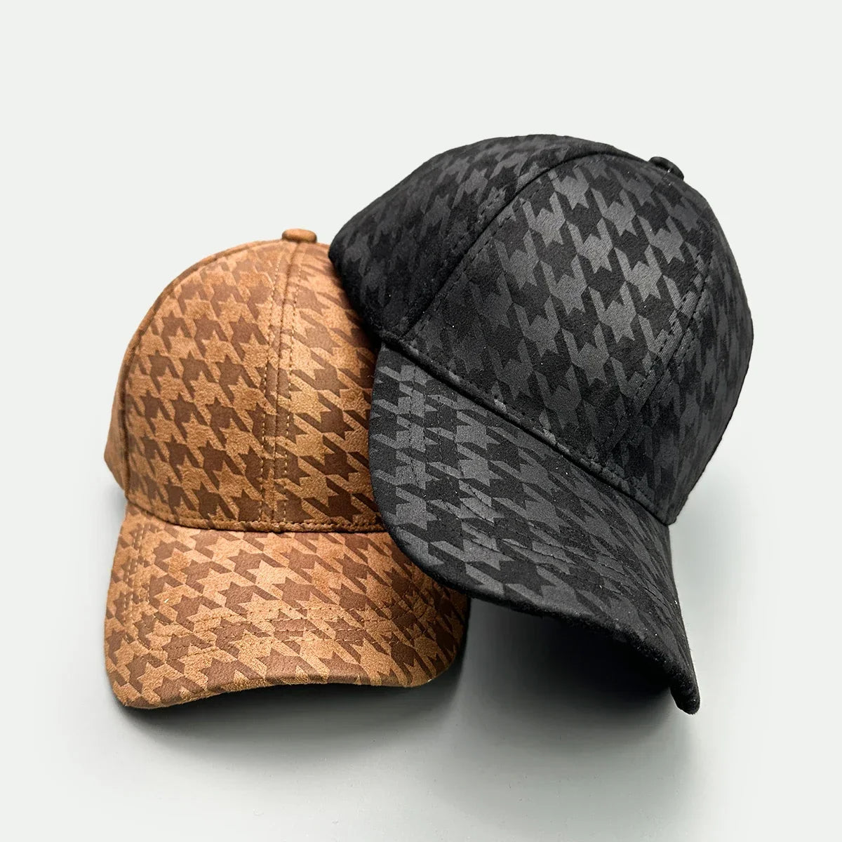 Two baseball caps with houndstooth pattern, one in brown and one in black.