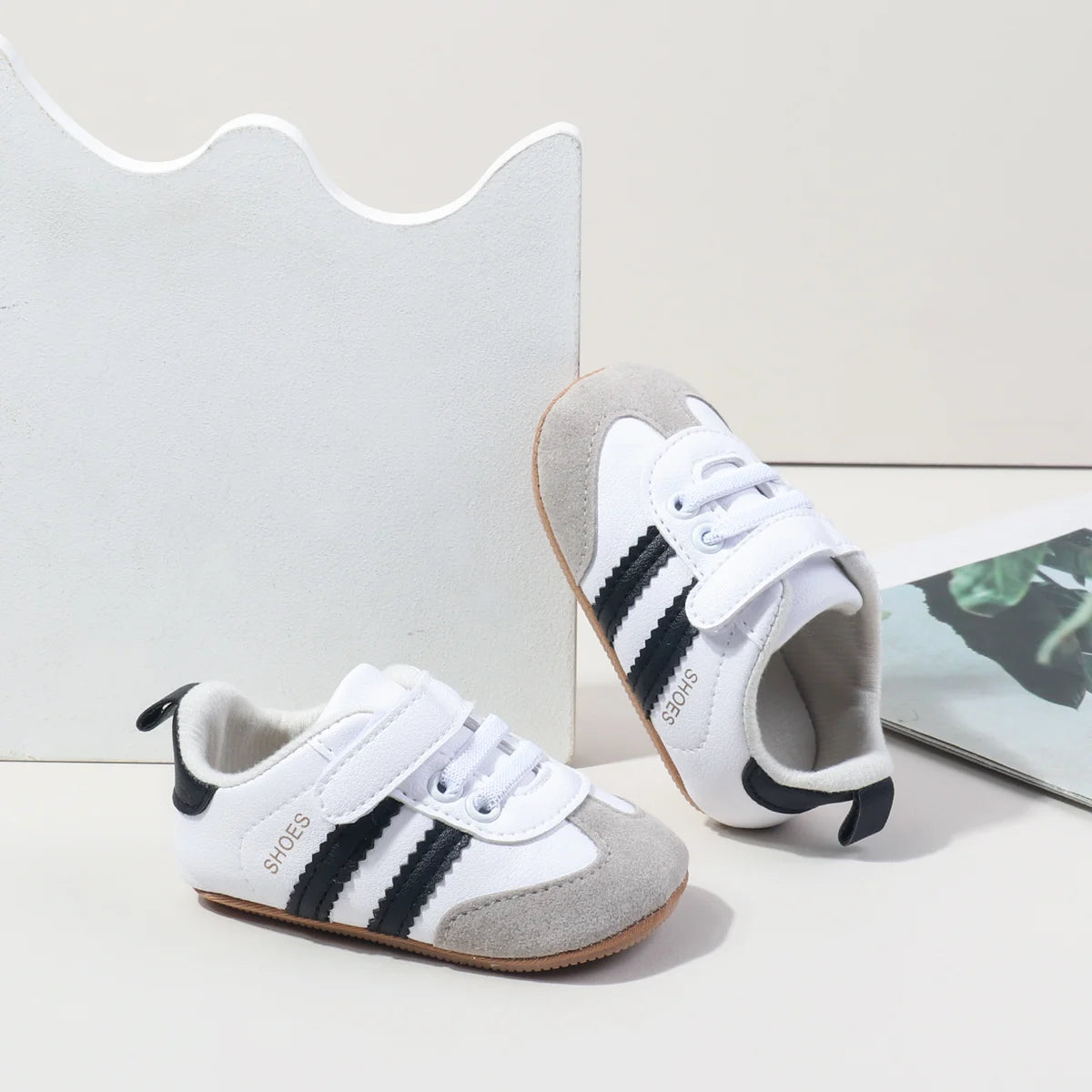 Baby first walker sneakers, white and gray with black trim and brown rubber sole