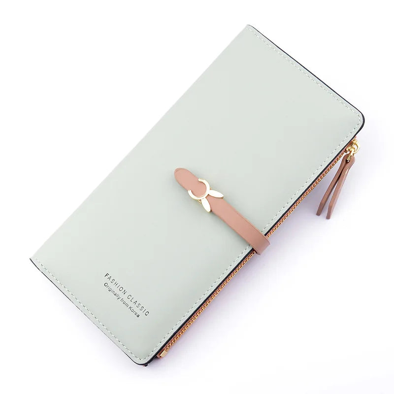 Long light blue leather wallet purse with bow strap, gold zipper, and long wallet shape.
