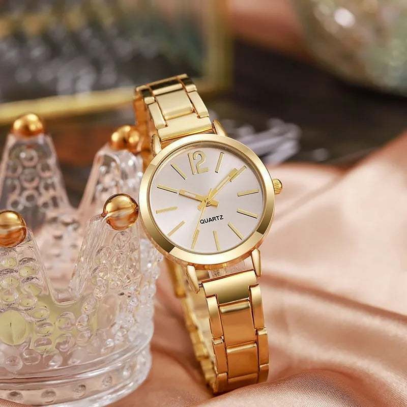 Women's quartz wristwatch with gold circular dial and metal link bracelet, minimalist markers.