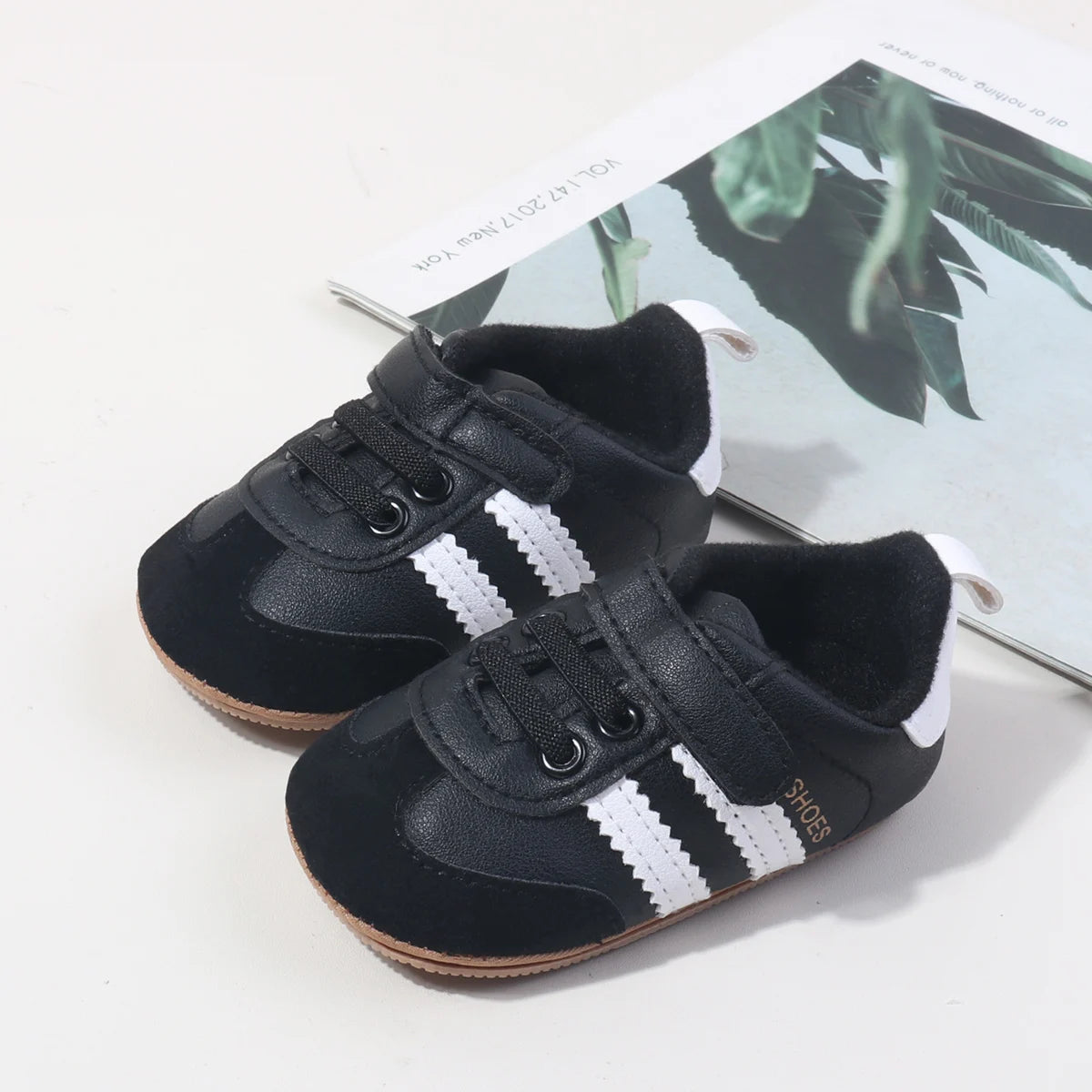 Baby first walker sneakers, two views of dark navy shoes with white side stripes