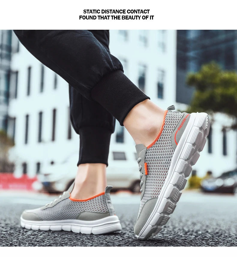 Gray mesh sneakers with orange collar trim and white sole with black pants