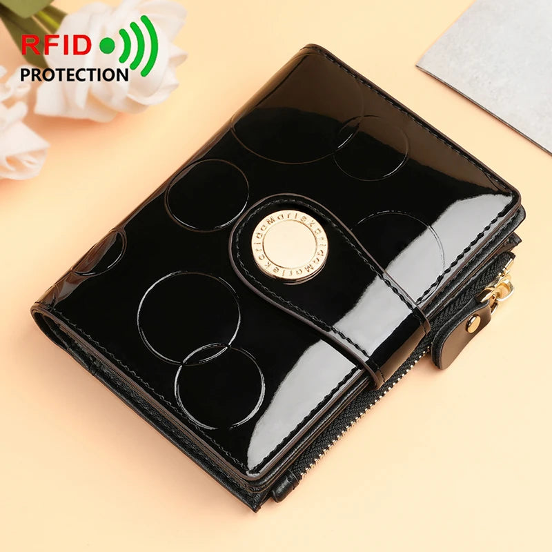 Black patent short wallet card holder with circular pattern and gold emblem, snap closure