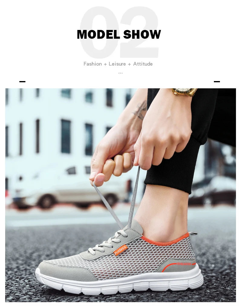 Gray lace-up mesh sneaker on foot with white sole and orange trim