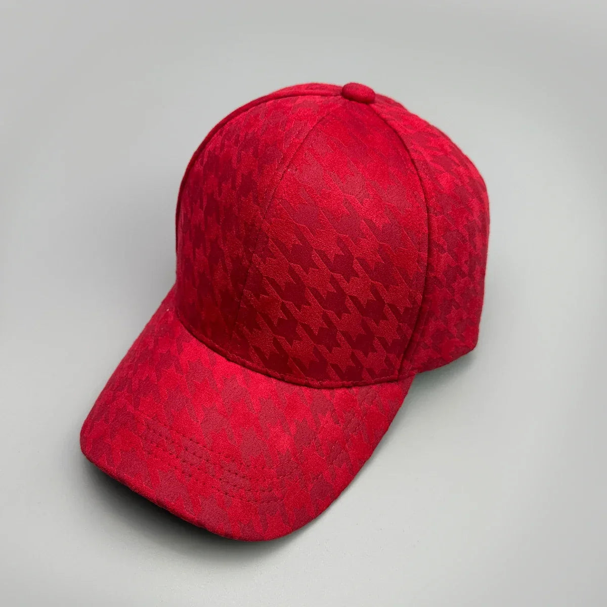 Red baseball cap with a subtle textured pattern on a grey background