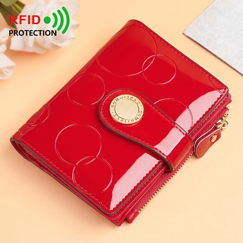 Red patent short wallet card holder with circular pattern, gold emblem and zipper edge