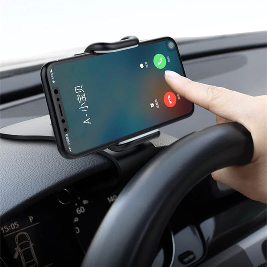 Black dashboard phone mount holding a smartphone with hand adjusting it