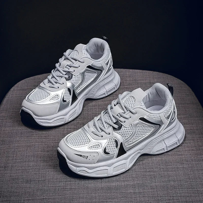 White chunky platform sneakers with dark logo accents and thick tread sole, side view