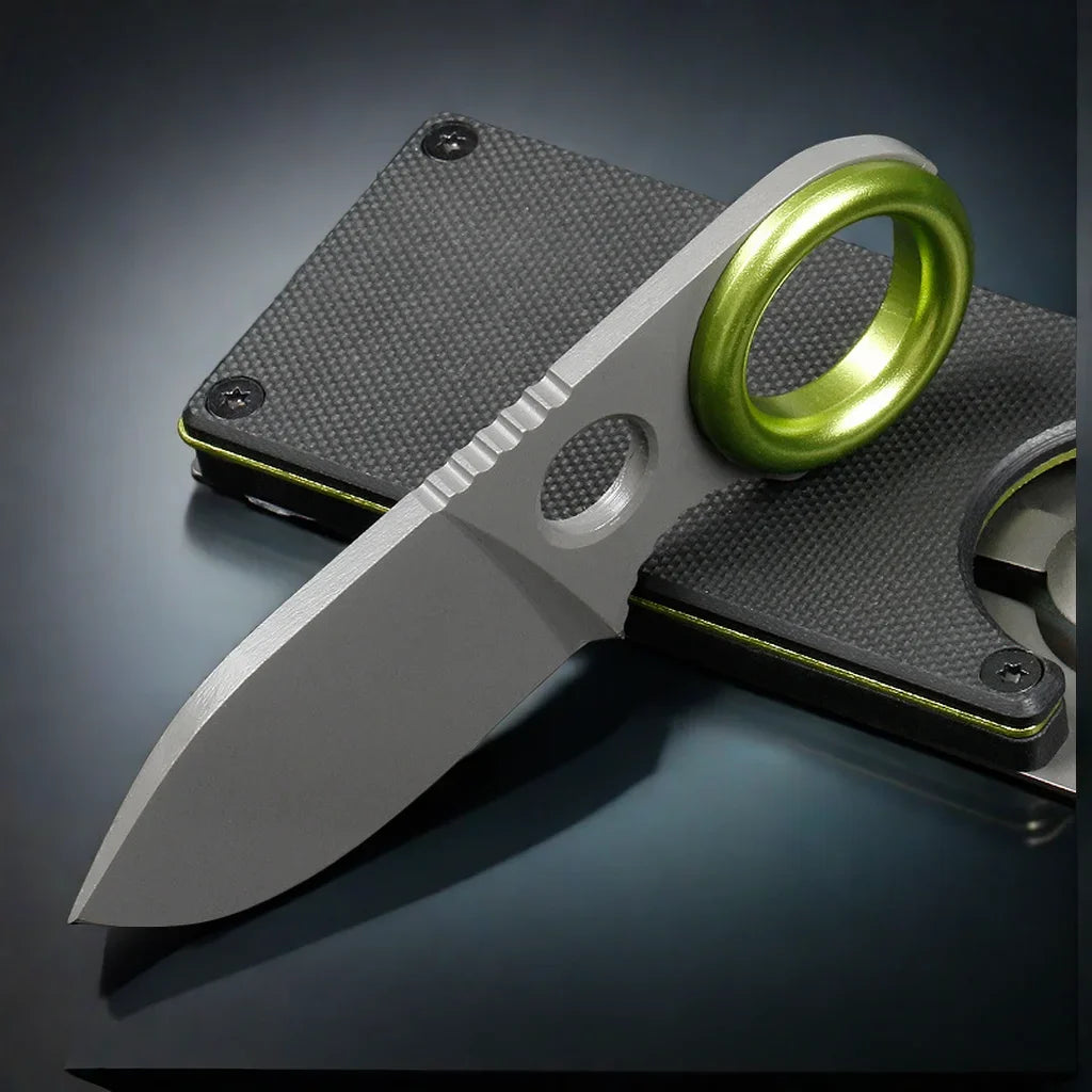 Stainless pocket knife keychain with dark handle, green ring, and textured back