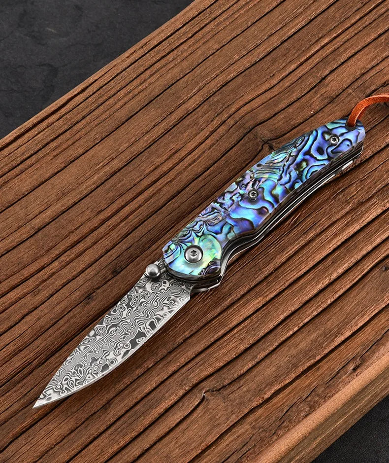 Damascus steel folding knife with iridescent blue handle and patterned damascus blade