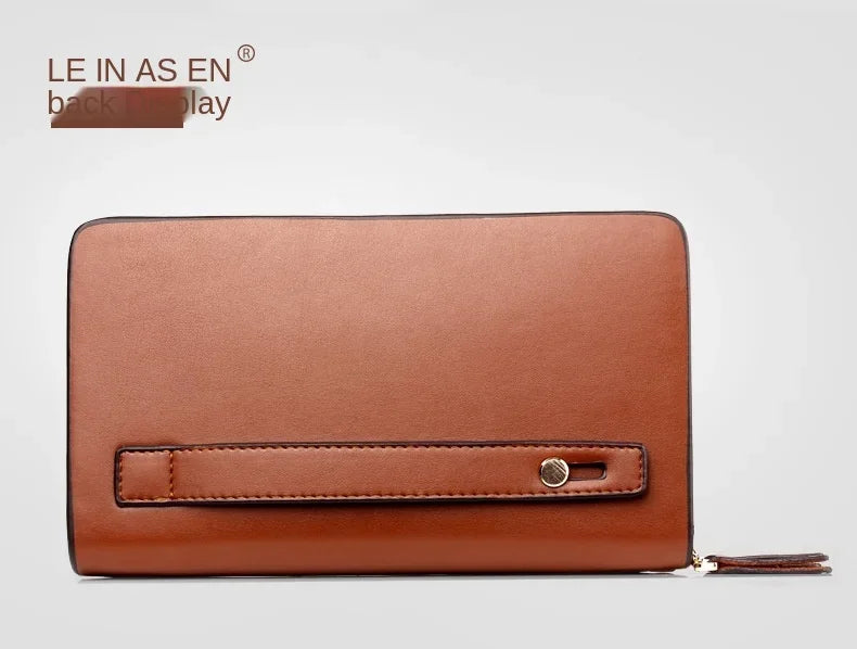 Brown leather wallet back view with stitched belt-like strap and metal snap tab